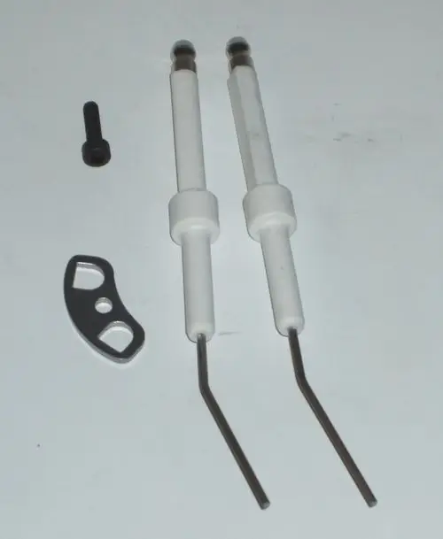 Zwei Zündelektroden von Daikin in weiß mit gebogenen Enden, begleitet von einem kleinen schwarzen Schraubenteil und einer metallischen Halterung.